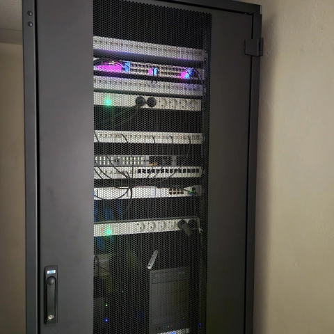 Kombinierter 19-Zoll-Netzwerk- und Serverschrank mit Patchpanels, LWL-Glasfaserverteiler, Switch, Steckdosenleisten und Servern.